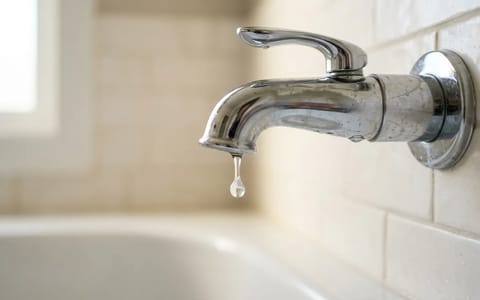 A dripping chrome bathtub faucet