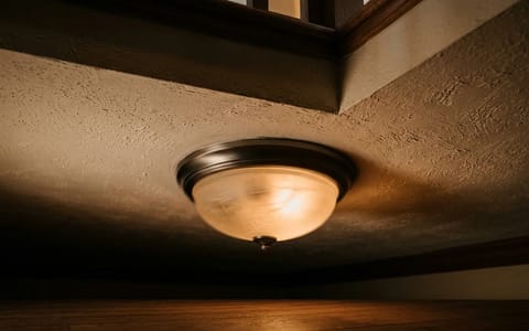 A ceiling light fixture vibrating and flickering due to footsteps on the floor above