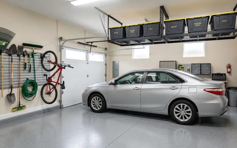 A perfectly organized one-car garage with a car parked inside and tools mounted on the walls.