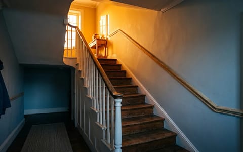 A home staircase showing a visual representation of cool air downstairs and hot air upstairs.