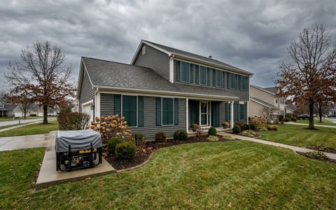 A well-prepared home with storm shutters closed and a cleared yard ahead of a hurricane.